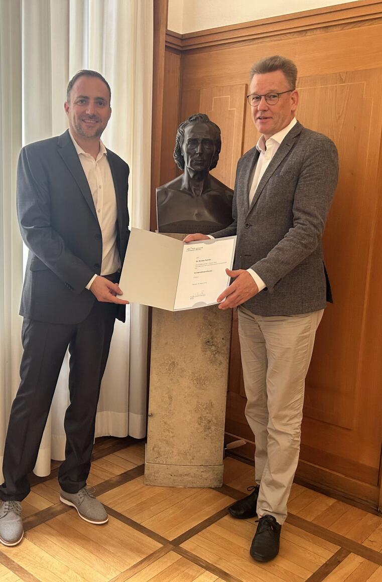 Das Bild zeigt Herrn Prof. Dr. Rohner (links) mit dem Rektor der Uni Münster, Prof. Dr. Wessels, bei der Übergabe der Ernennungsurkunde