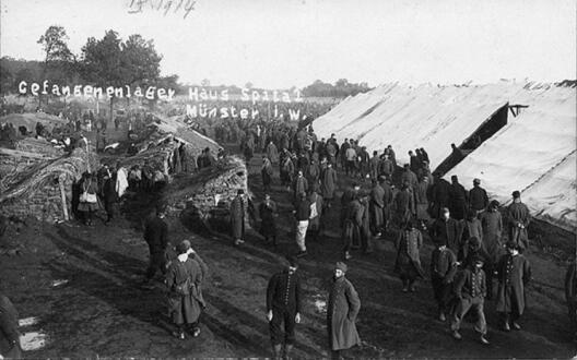 Fotografie von Kriegsgefangenen im Notlager Haus Spital, mit Erdhütten als Notunterkünften und Windunterständen, September 1914 (Quelle: Stadtarchiv Münster, Fotosammlung Nr. 3799)