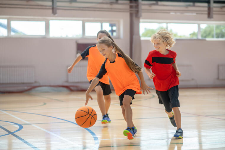 Kinder spielen Basketball