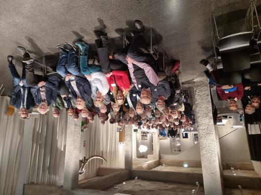 Eine große Gruppe von Personen sitzt in einem Saal.