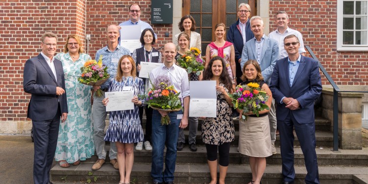 Rector Prof. Dr. Johannes Wessels (front left) and Rector Magnificus Prof. Dr. Tom Veldkamp (front right) congratulate the four winning teams.<address>© WWU - MünsterView</address>