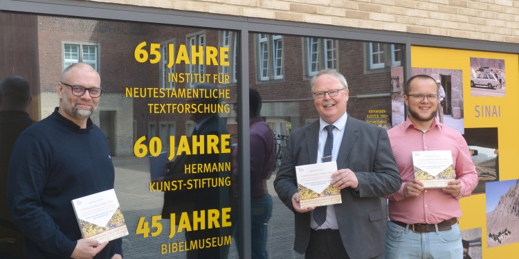 Kustos Dr. Jan Graefe, Prof. Dr. Holger Strutwolf, Direktor des Bibelmuseums, und Johannes Claßen (Wissenschaftliche Hilfskraft) präsentieren den Katalog zur Jubiläumsausstellung (v.l.).<address>© Uni MS – Brigitte Heeke</address>