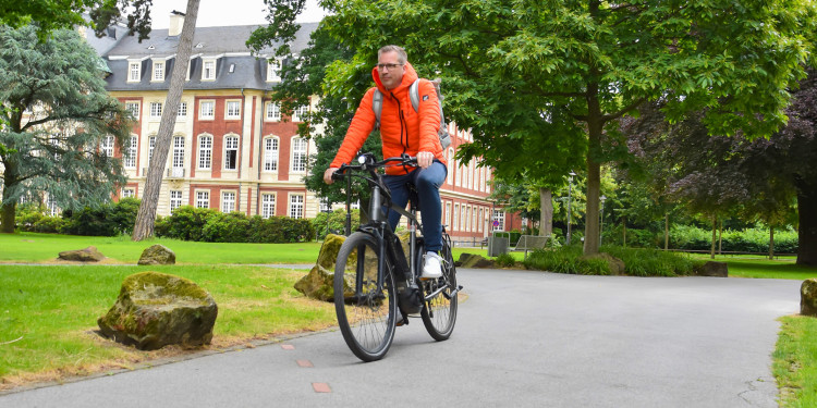 Mit dem Rad pendelt Daniel Kuhmann zwischen seinem Büro und den Gebäuden, für die er zuständig ist.<address>© Uni MS - Linus Peikenkamp</address>