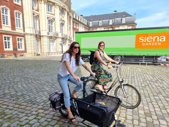 Mit dem Fahrrad fahren Christiane Borgmann und Nicole Kleinhölting (v.l.) vom Kongressmanagement in der Stadt zu verschiedenen Ortsterminen.<address>© Uni MS - Brigitte Heeke</address>