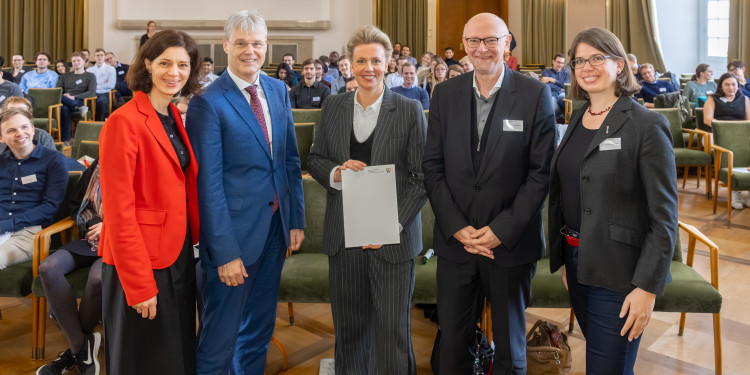 Ministerin Ina Brandes (Mitte) überreichte Dr. Julia Quante, Prorektor Prof. Dr. Michael Quante (v.l.), Prof. Dr. Martin Winter und Dr. Kerstin Neuhaus den Förderbescheid für die internationale Forschungsschule „BACCARA“ an der Universität Münster.<address>© Uni MS - MünsterView</address>