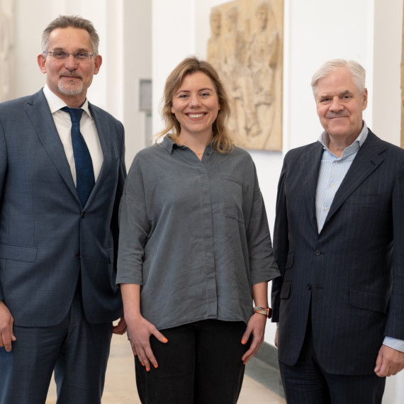 Auf dem Bild sind Dekan Prof. Dr. Thomas Langer, Dr. Verena Löffler und Prof. Dr. Andreas R. Dombret (v.l.) zu sehen. Sie stehen nebeneinander im Foyer vor der Aula im Schloss und blicken in die Kamera.<address>© Uni MS - Brigitte Heeke</address>