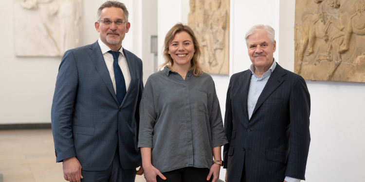 Auf dem Bild sind Dekan Prof. Dr. Thomas Langer, Dr. Verena Löffler und Prof. Dr. Andreas R. Dombret (v.l.) zu sehen. Sie stehen nebeneinander im Foyer vor der Aula im Schloss und blicken in die Kamera.<address>© Uni MS - Brigitte Heeke</address>