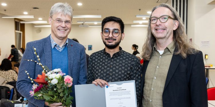 Zu sehen sind Prorektor Prof. Dr. Michael Quante, Yash Gupta und Prof. Dr. Mark Stein (v.l.). Der Preisträger hält seine Urkunde in der Hand.<address>© Uni MS - Peter Leßmann</address>