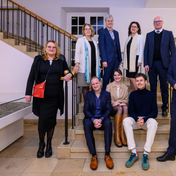 Rektor Prof. Dr. Johannes Wessels (r.) und das gesamte Rektorat gratulierte den Preisträgern Rosa Herzog (sitzend, Mitte), Till Pauly (sitzend rechts) und Prof. Dr. Dr. Udo Dannlowski (sitzend links).<address>© Uni MS - Michael Möller</address>