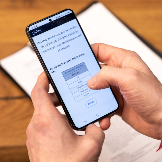 Eine Person hält ein Smartphone in den Händen, auf dem eine Frage der Studie zu sehen ist.<address>© Uni MS - Johannes Wulf</address>